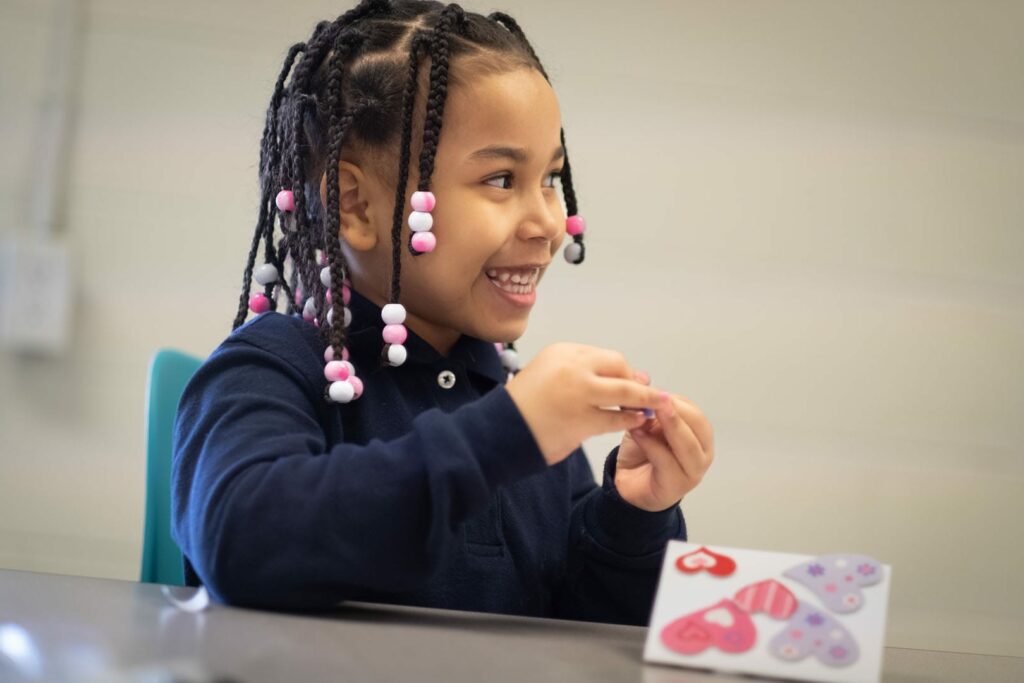 Smiling little girl with beads in her hair.