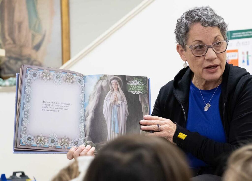 Woman reading a religious text to children.